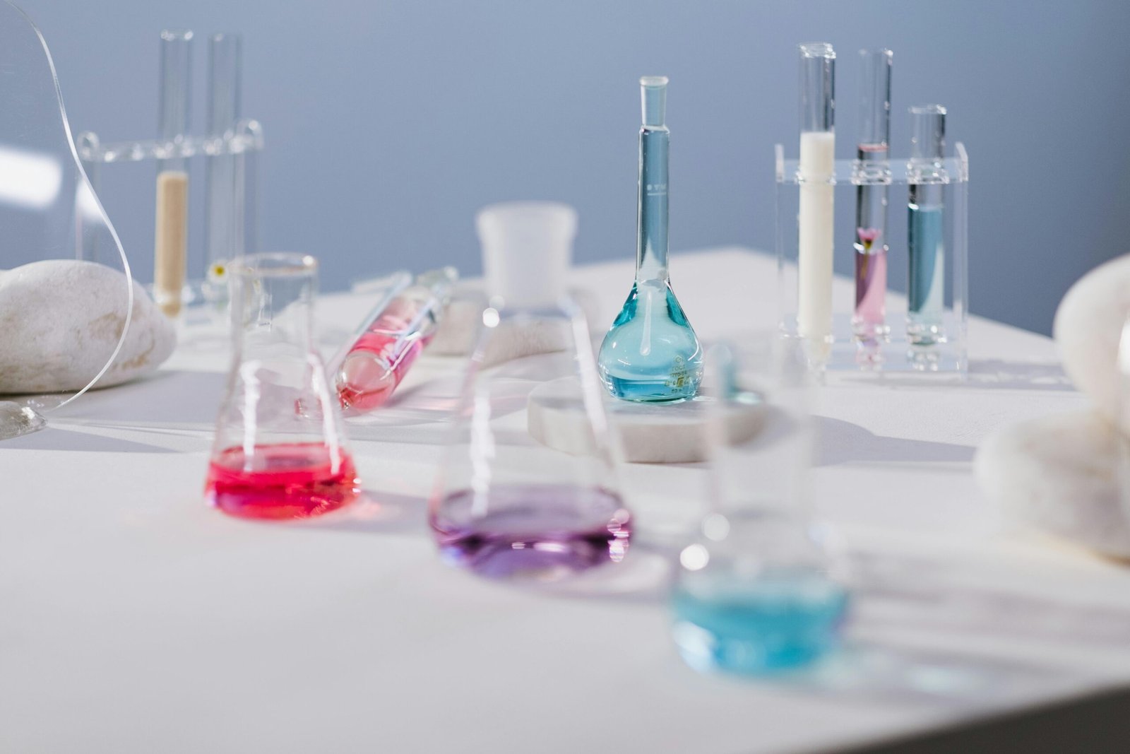 Vibrant liquids in glassware on a laboratory table in a modern science setting.